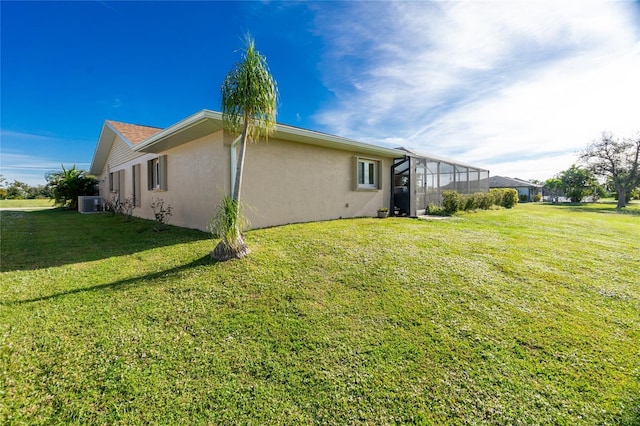 view of property exterior with a yard, a lanai, and central AC