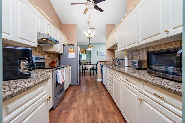 kitchen with white cabinets, stainless steel appliances, and light stone countertops