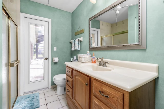 bathroom featuring toilet, tile patterned flooring, an enclosed shower, and vanity