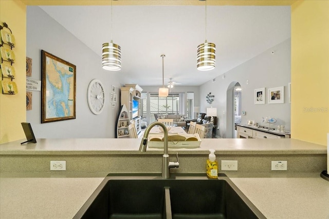 kitchen featuring decorative light fixtures, ceiling fan, and sink