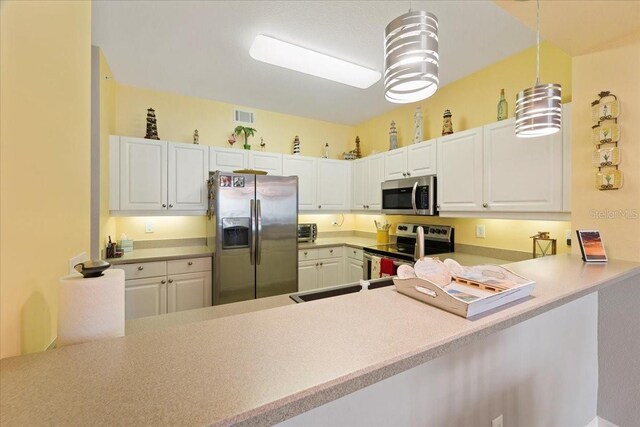 kitchen featuring pendant lighting, white cabinets, kitchen peninsula, and stainless steel appliances