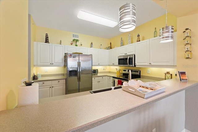 5127 Melbourne St Unit F-204, Port Charlotte, FL 33980 - kitchen with appliances with stainless steel finishes, a peninsula, light countertops, hanging light fixtures, and white cabinetry