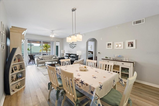5127 Melbourne St Unit F-204, Port Charlotte, FL 33980 - dining space featuring arched walkways, ceiling fan, and light wood-style flooring