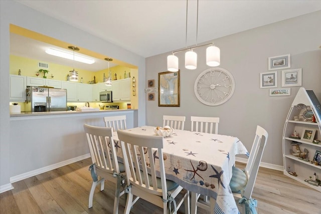 dining space with light hardwood / wood-style floors