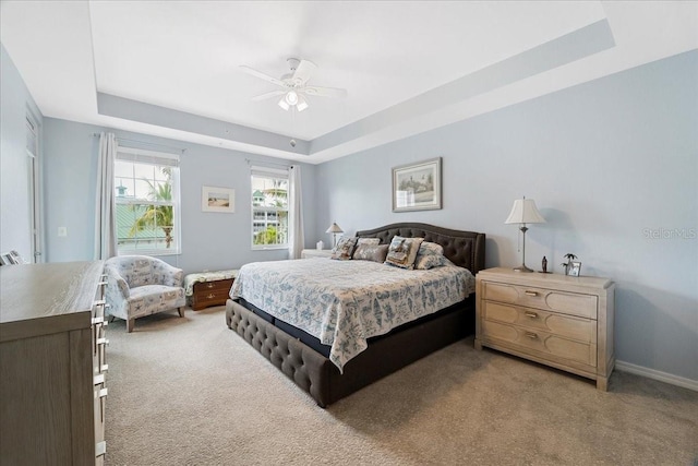 bedroom featuring carpet flooring, a raised ceiling, and ceiling fan