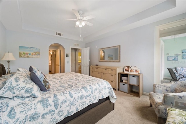 5127 Melbourne St Unit F-204, Port Charlotte, FL 33980 - bedroom with a tray ceiling, arched walkways, light colored carpet, and a ceiling fan