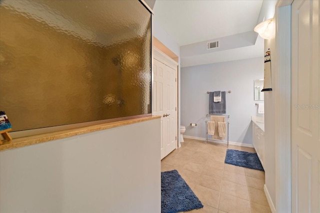 bathroom featuring tile patterned floors, toilet, and a shower with door