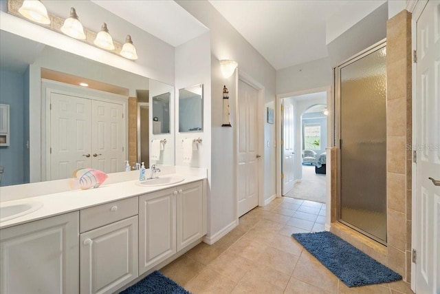 bathroom featuring tile patterned floors, vanity, and a shower with shower door