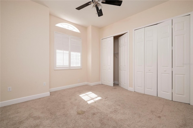 unfurnished bedroom featuring ceiling fan, two closets, and light colored carpet