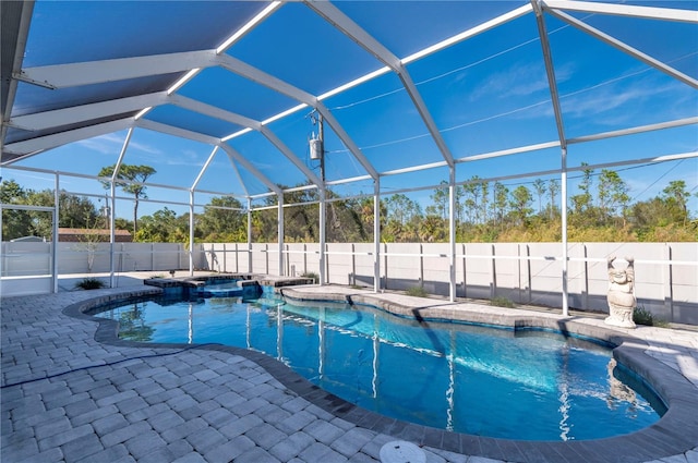 view of pool with an in ground hot tub, glass enclosure, and a patio