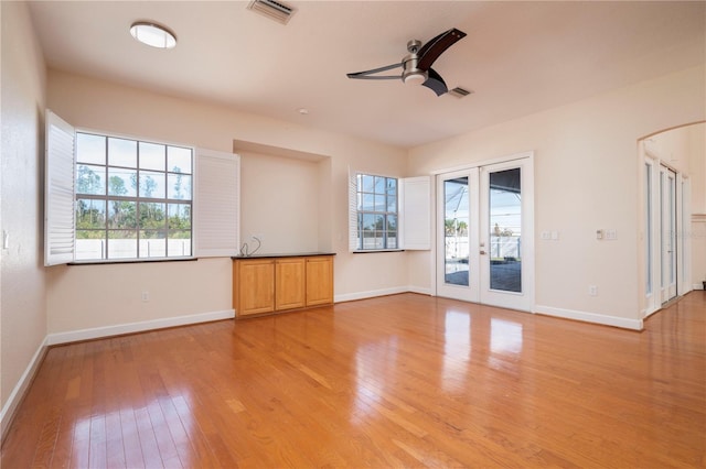 unfurnished living room featuring ceiling fan, light hardwood / wood-style floors, and french doors