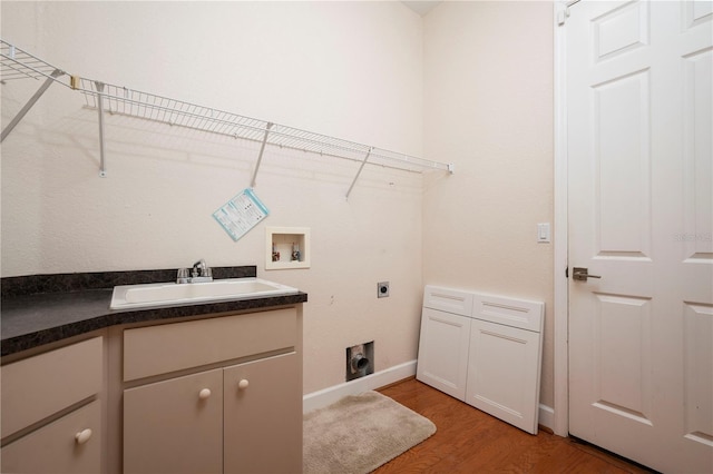 clothes washing area featuring electric dryer hookup, washer hookup, cabinets, light hardwood / wood-style flooring, and sink