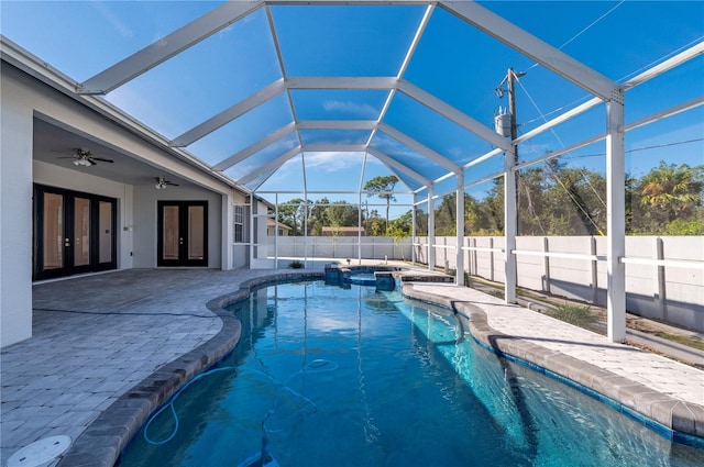 view of swimming pool featuring ceiling fan, a patio area, an in ground hot tub, a lanai, and french doors