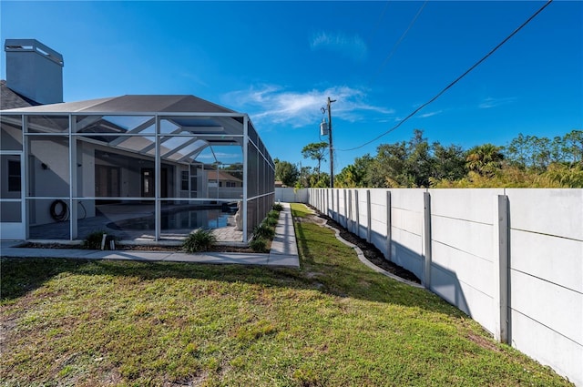 view of yard with a fenced in pool and glass enclosure