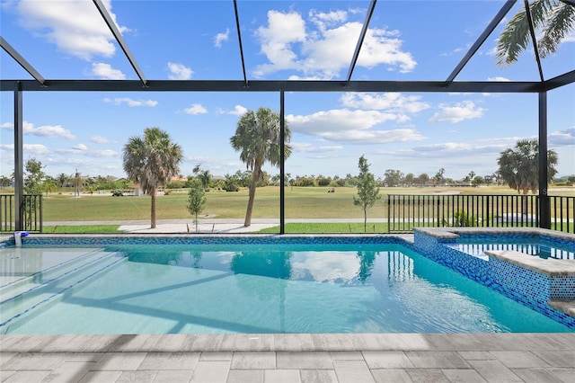 view of pool with a yard, glass enclosure, and an in ground hot tub