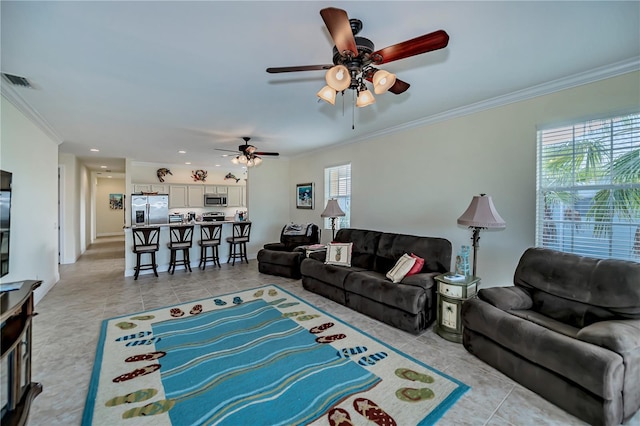 living room with ornamental molding, light tile patterned floors, and ceiling fan