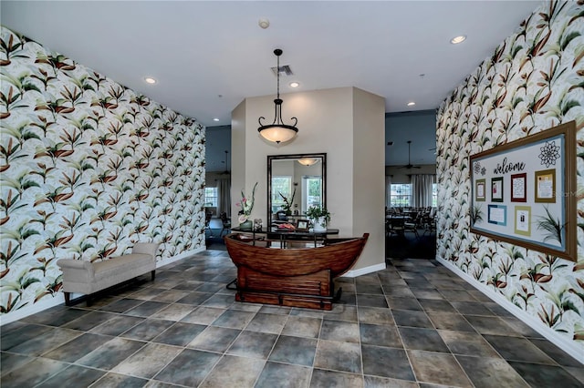 interior space with recessed lighting, visible vents, an accent wall, and wallpapered walls