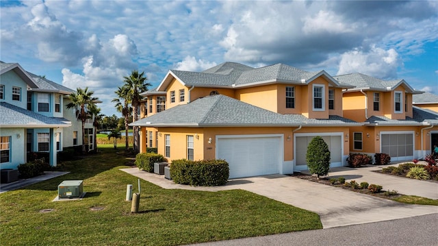 view of property featuring a garage, stucco siding, driveway, and a front lawn