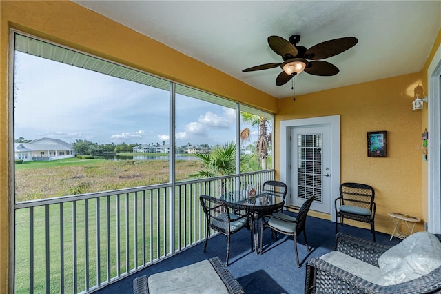 sunroom / solarium with visible vents, ceiling fan, and a water view