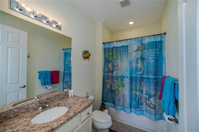 bathroom featuring visible vents, toilet, vanity, and shower / tub combo