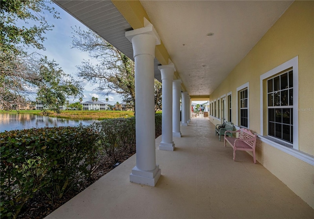 view of patio with a porch and a water view