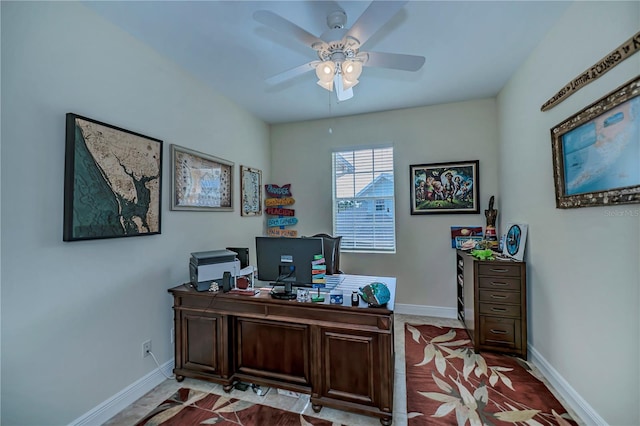 office area with a ceiling fan and baseboards