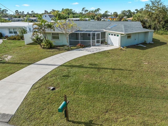 view of front facade featuring a sunroom, a front yard, and a garage