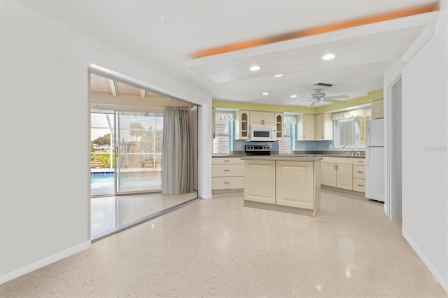 kitchen with cream cabinets, white appliances, and plenty of natural light