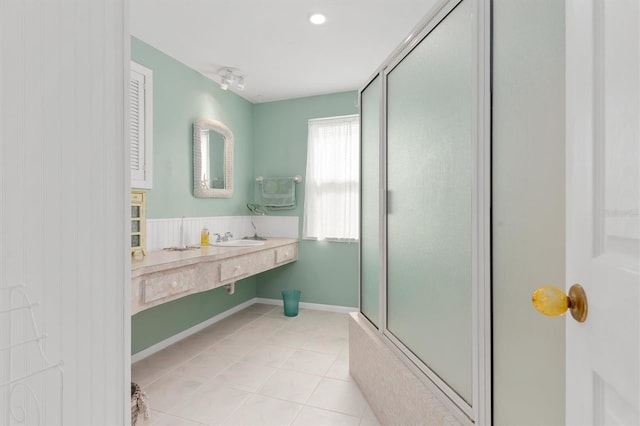 bathroom featuring an enclosed shower, sink, and tile patterned flooring