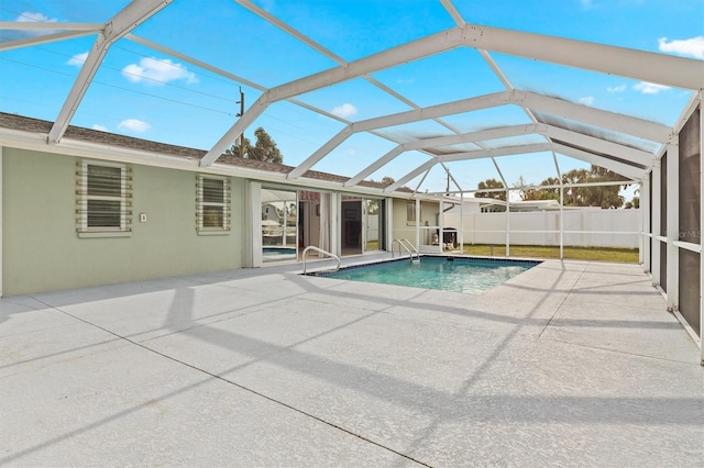 view of swimming pool featuring a patio and a lanai