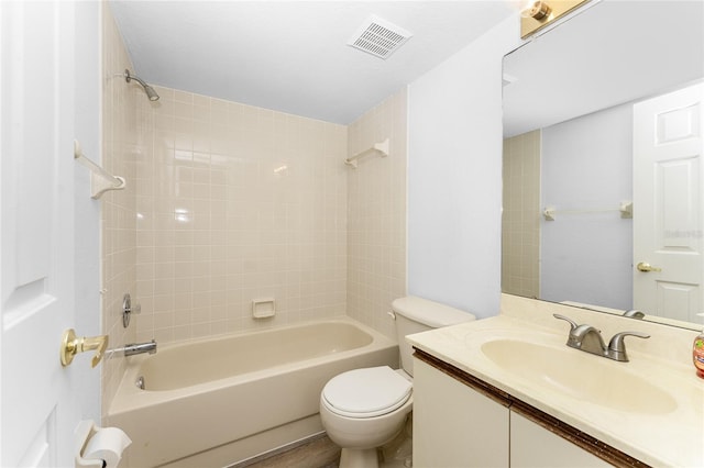 full bathroom featuring tiled shower / bath combo, vanity, and toilet