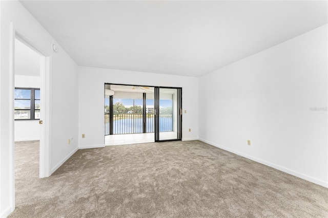 carpeted spare room with a water view