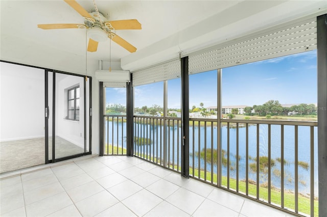 unfurnished sunroom with a water view and ceiling fan