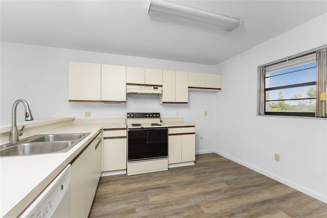 kitchen featuring hardwood / wood-style flooring, cream cabinets, sink, and white appliances