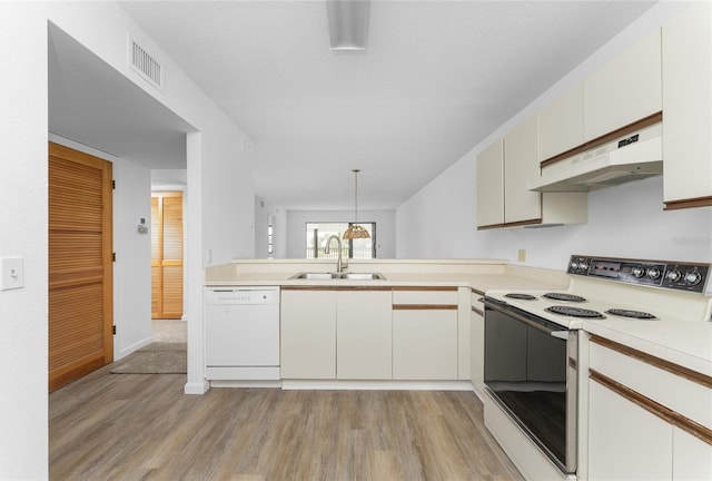 kitchen featuring sink, hanging light fixtures, light hardwood / wood-style flooring, kitchen peninsula, and white appliances