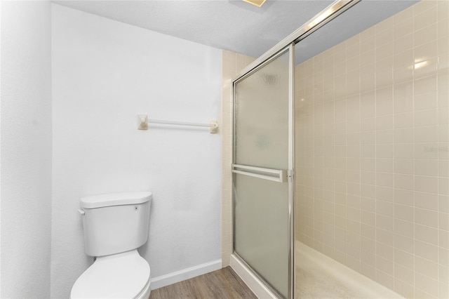 bathroom featuring wood-type flooring, toilet, and walk in shower