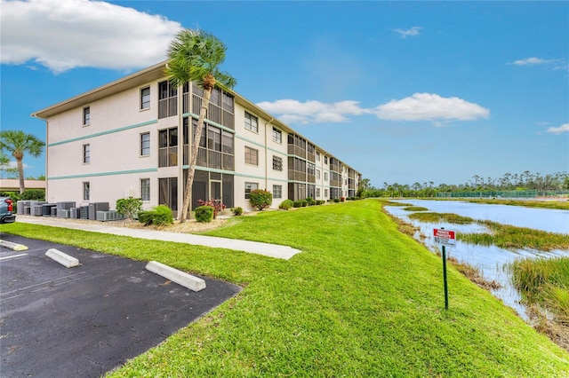 view of home's community featuring a lawn and a water view