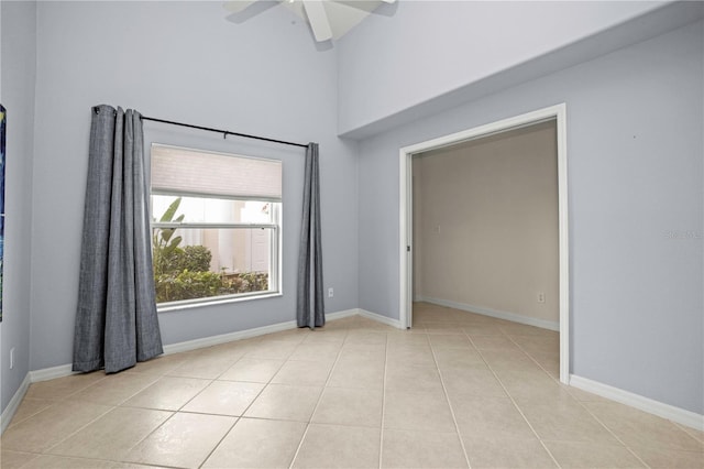 spare room with ceiling fan and light tile patterned floors