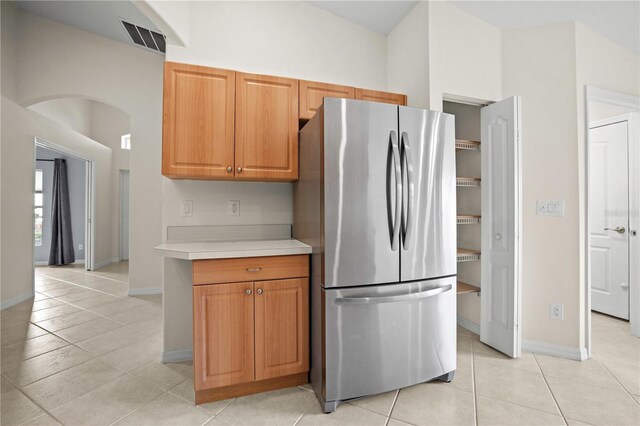 kitchen with light tile patterned floors and stainless steel refrigerator