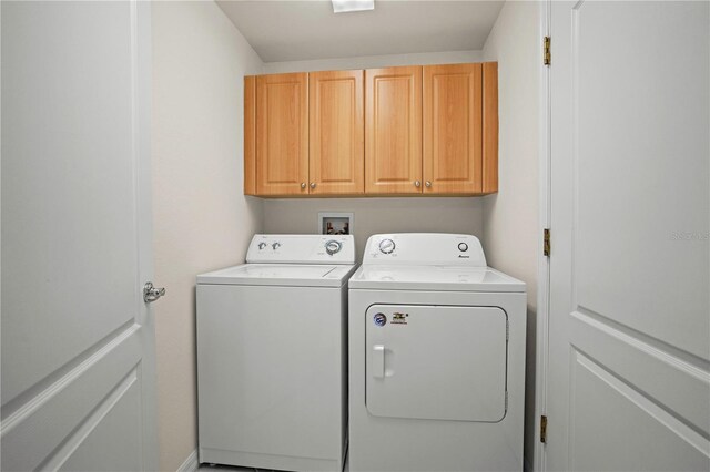 washroom featuring washing machine and clothes dryer and cabinets