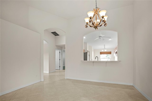 spare room featuring ceiling fan with notable chandelier and light tile patterned floors