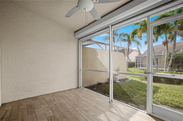 unfurnished sunroom featuring a wealth of natural light and ceiling fan