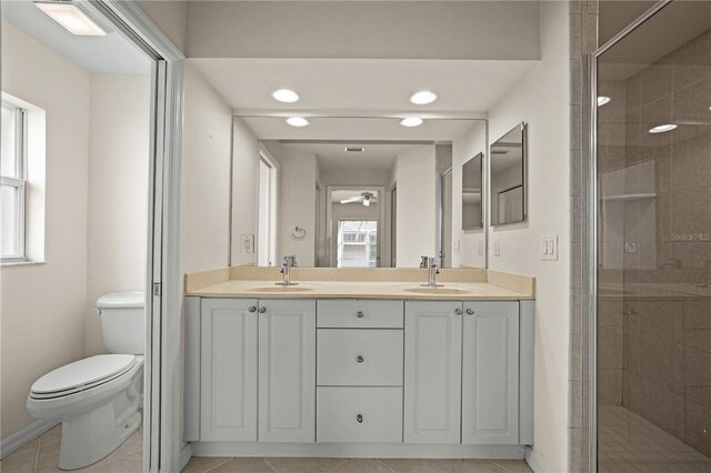 bathroom featuring an enclosed shower, vanity, ceiling fan, tile patterned flooring, and toilet