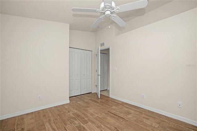 unfurnished bedroom with ceiling fan, a closet, and light wood-type flooring