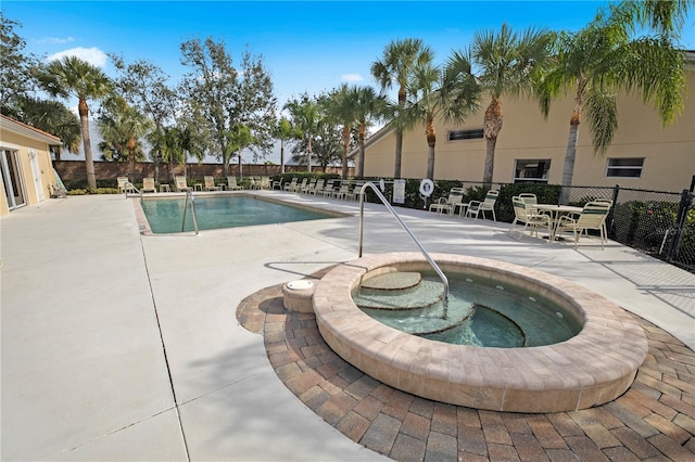 view of pool with a hot tub and a patio area