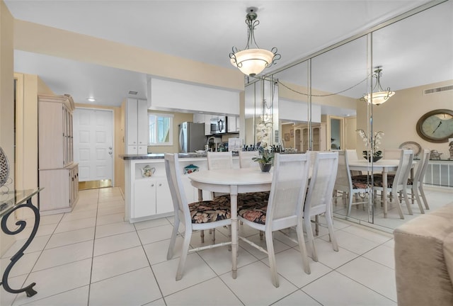 dining area featuring light tile patterned floors and visible vents