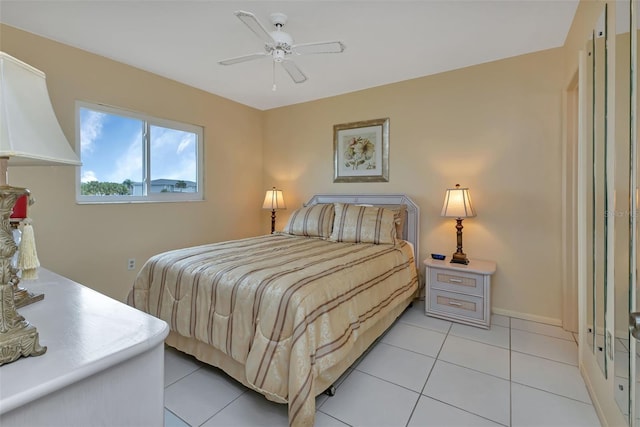 bedroom featuring light tile patterned floors, a ceiling fan, and baseboards