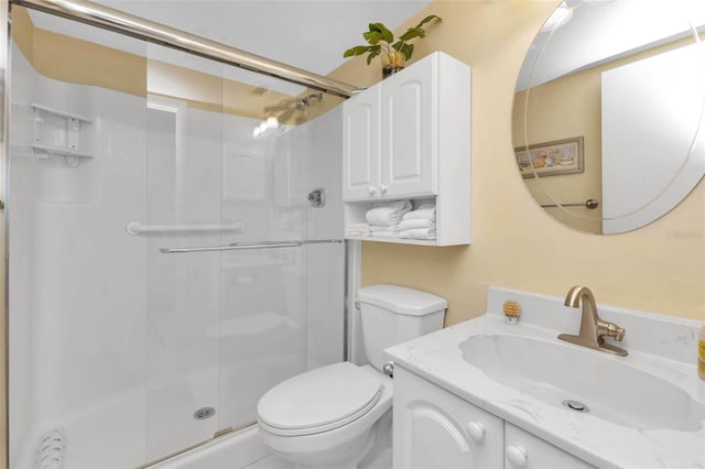 full bathroom with a stall shower, vanity, and toilet