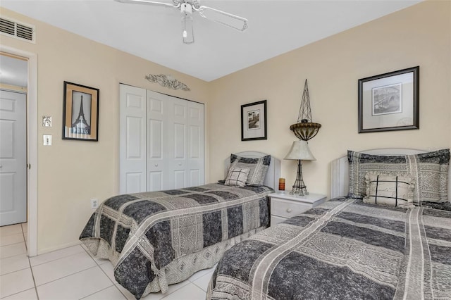 tiled bedroom with ceiling fan and a closet