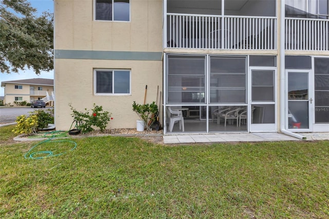 back of property with a balcony and a yard